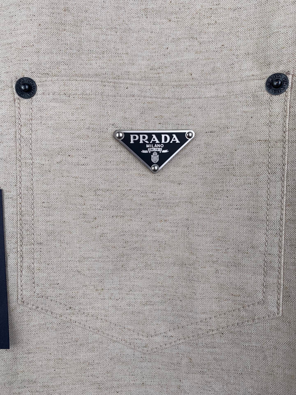 Beige shirt chest pocket with PRADA logo triangle patch and two buttons