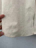 Beige shirt lower body and hem with visible stitching and texture