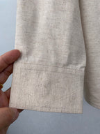 Beige shirt sleeve cuff and hem with dark button detail
