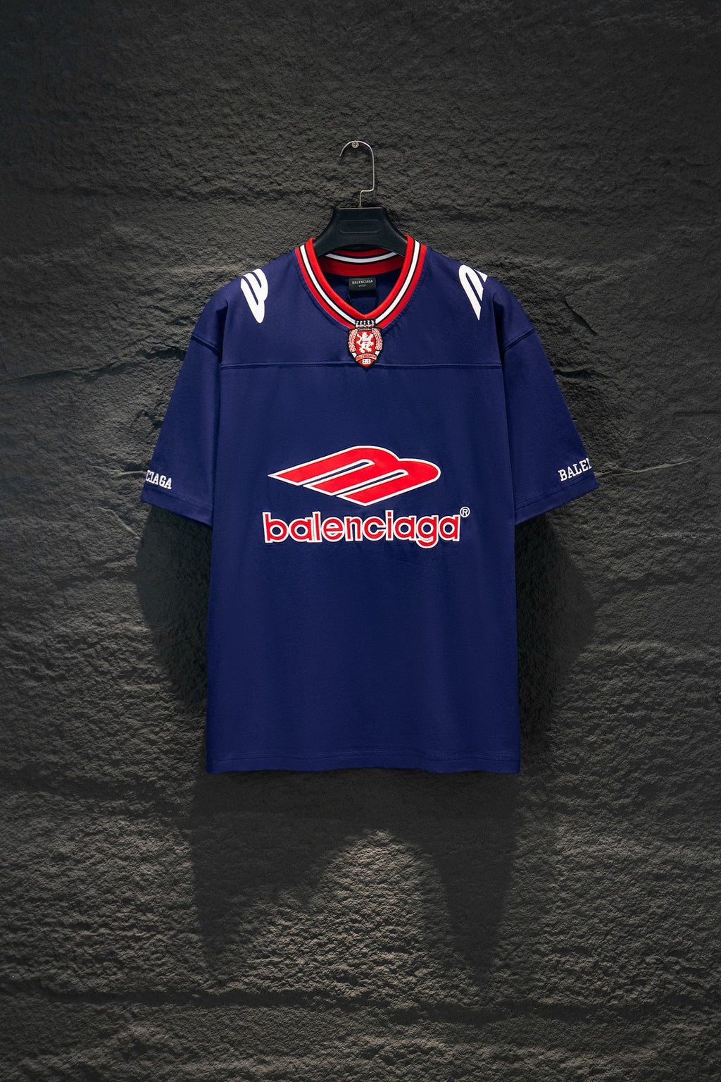 Balenciaga blue short-sleeve shirt with red-and-white striped collar and crest emblem
