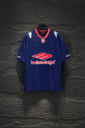 Balenciaga blue short-sleeve shirt with red-and-white striped collar and crest emblem