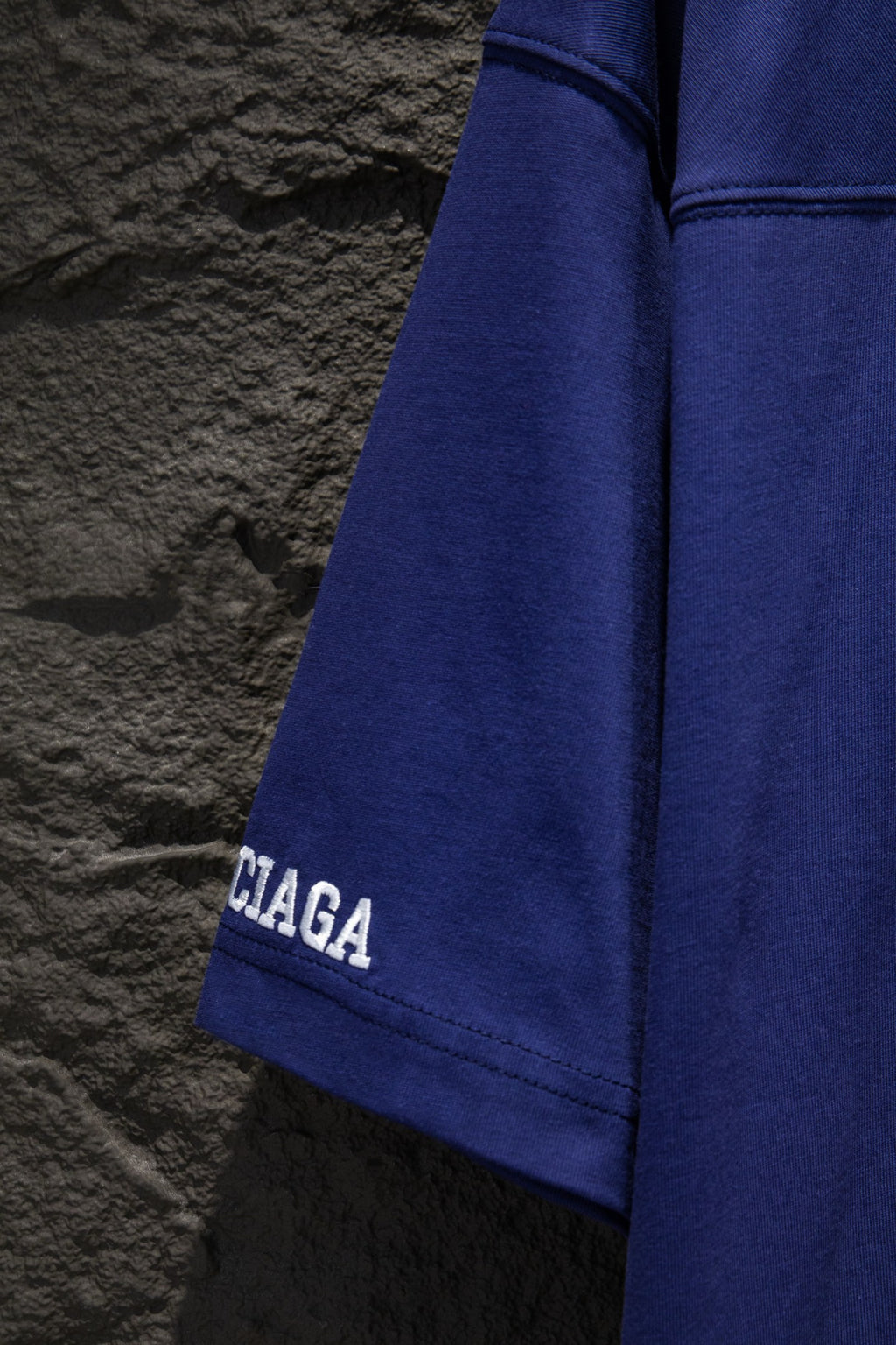 Balenciaga blue short-sleeve shirt side view with partial Balenciaga sleeve logo