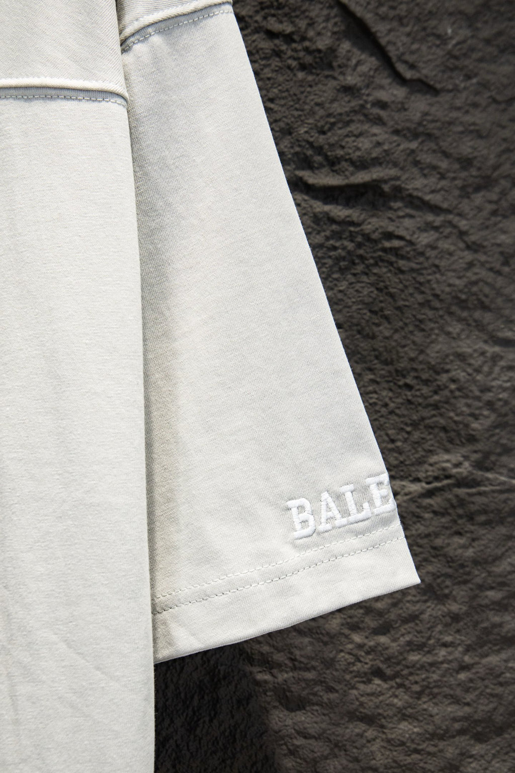 Balenciaga white T-shirt sleeve with blue logo print near cuff