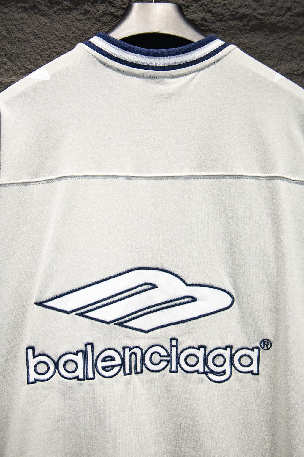 Balenciaga white T-shirt front close-up with blue logo and thin stripe seam