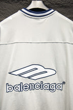 Balenciaga white T-shirt front close-up with blue logo and thin stripe seam