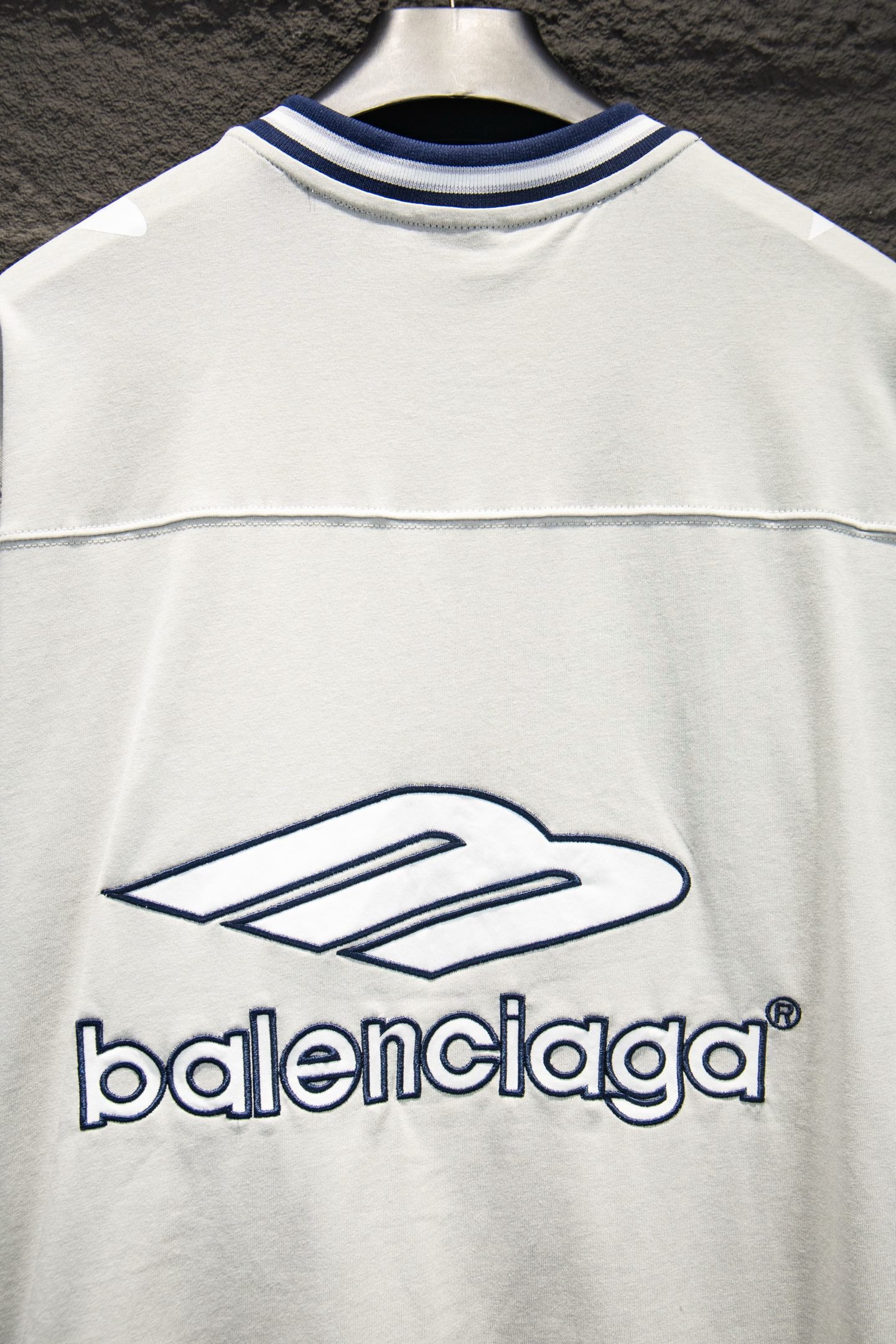 Balenciaga white T-shirt front close-up with blue logo and thin stripe seam