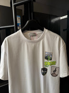 White Dior short-sleeve T-shirt with centered chest graphic badges, front close-up