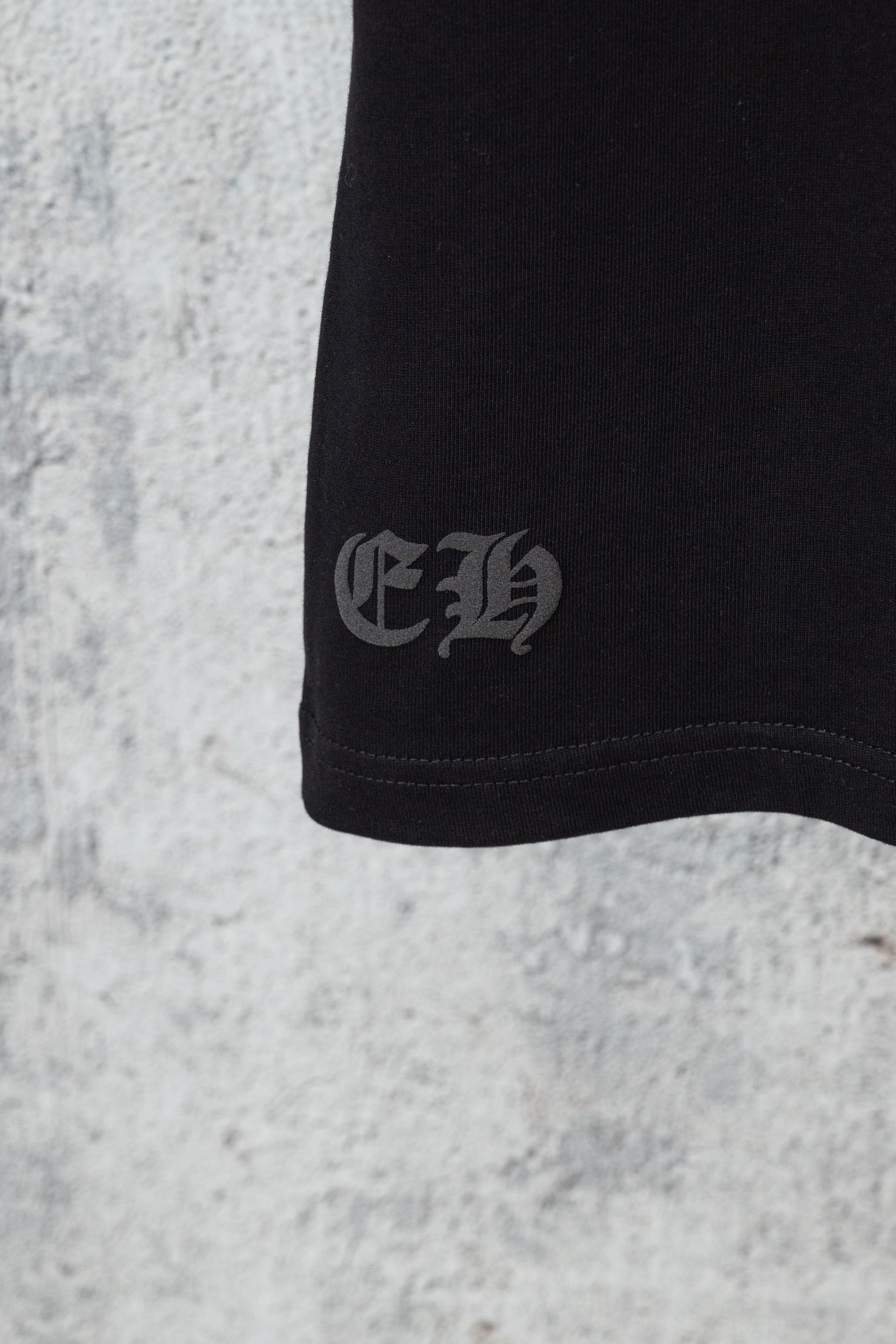 Black shorts hem with small embroidered logo near cuff