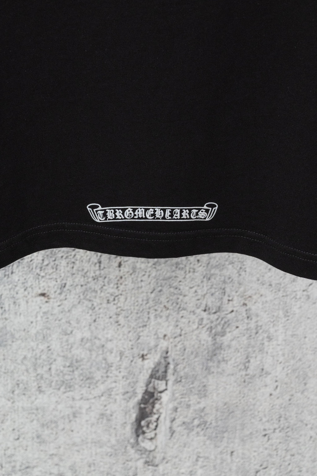 Black crew-neck T-shirt neckline with white logo text band