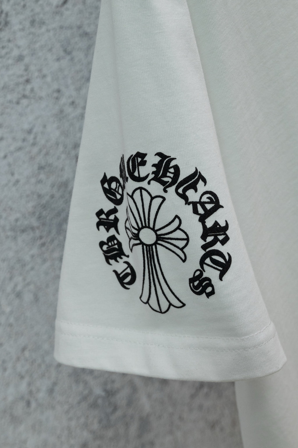 White T-shirt hem with cross-style graphic print detail