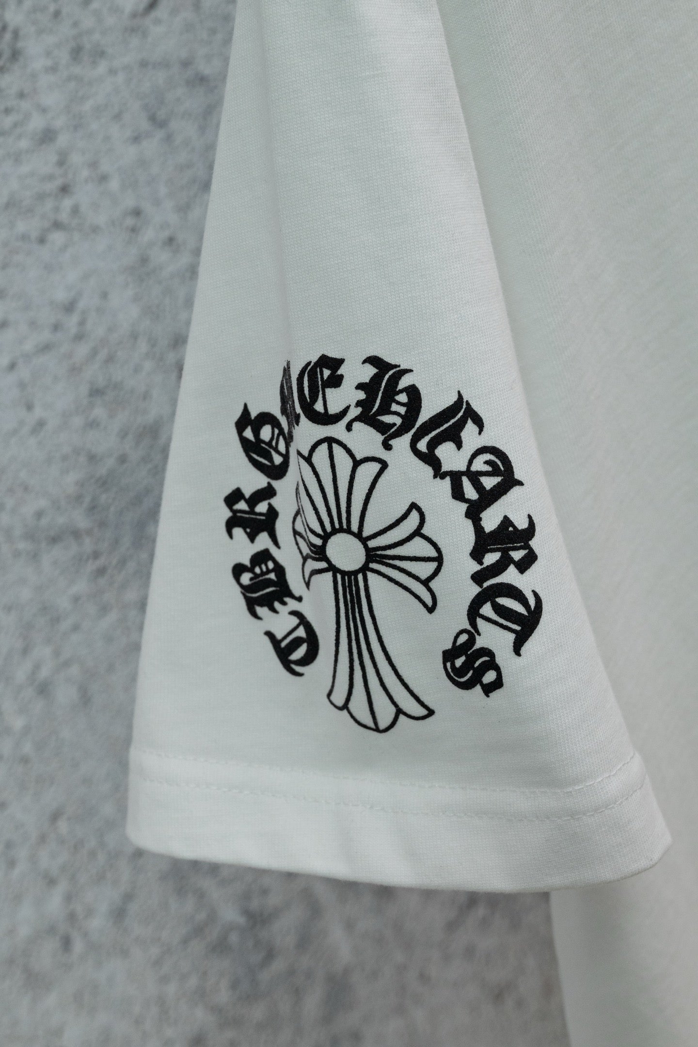 White T-shirt hem with cross-style graphic print detail