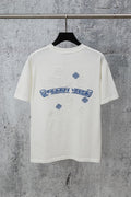 White graphic T-shirt with blue embroidered-style logo and small cross-like accents