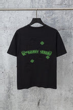 Black graphic T-shirt with green logo print and small cross-like pattern details