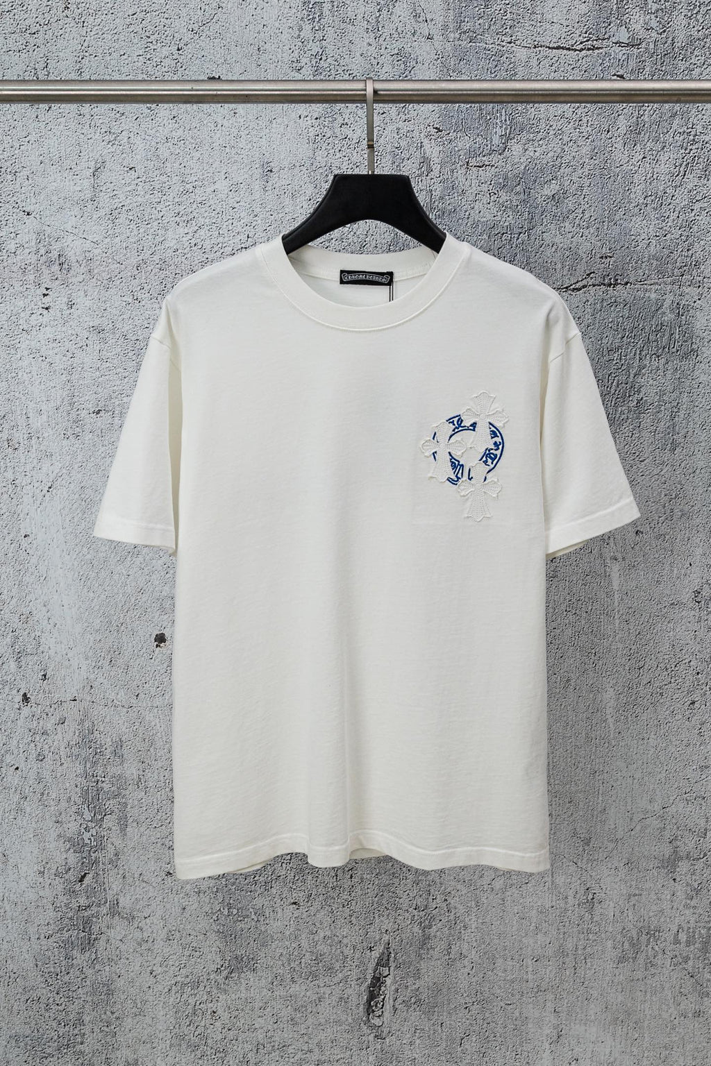 White graphic T-shirt with small blue chest logo and short-sleeve crew neck