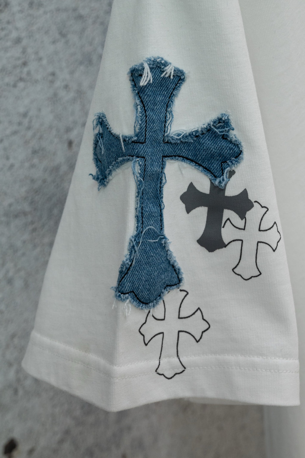 White short-sleeve T-shirt with blue denim-style cross applique