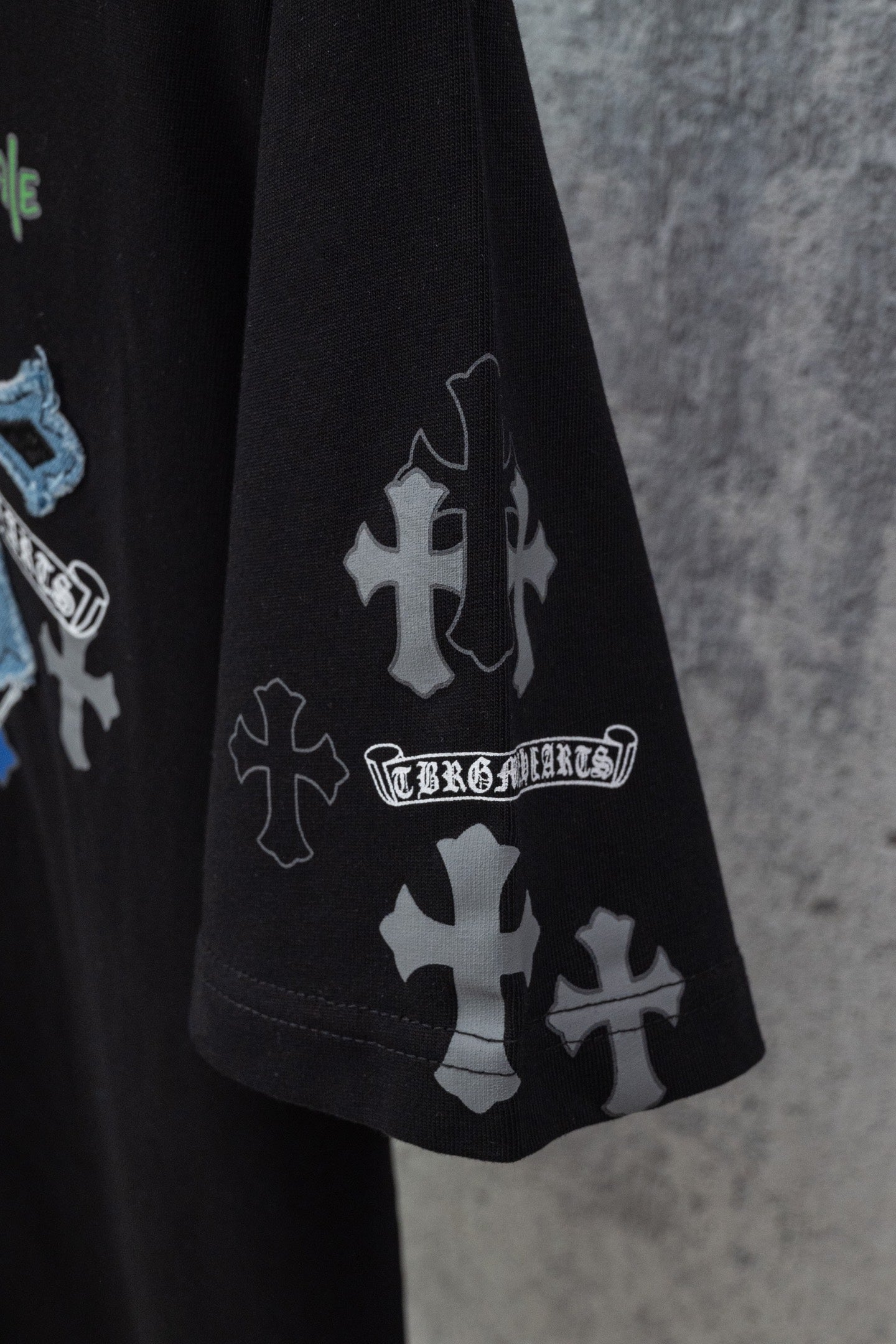 Black short-sleeve T-shirt with white cross emblem print on sleeve and side