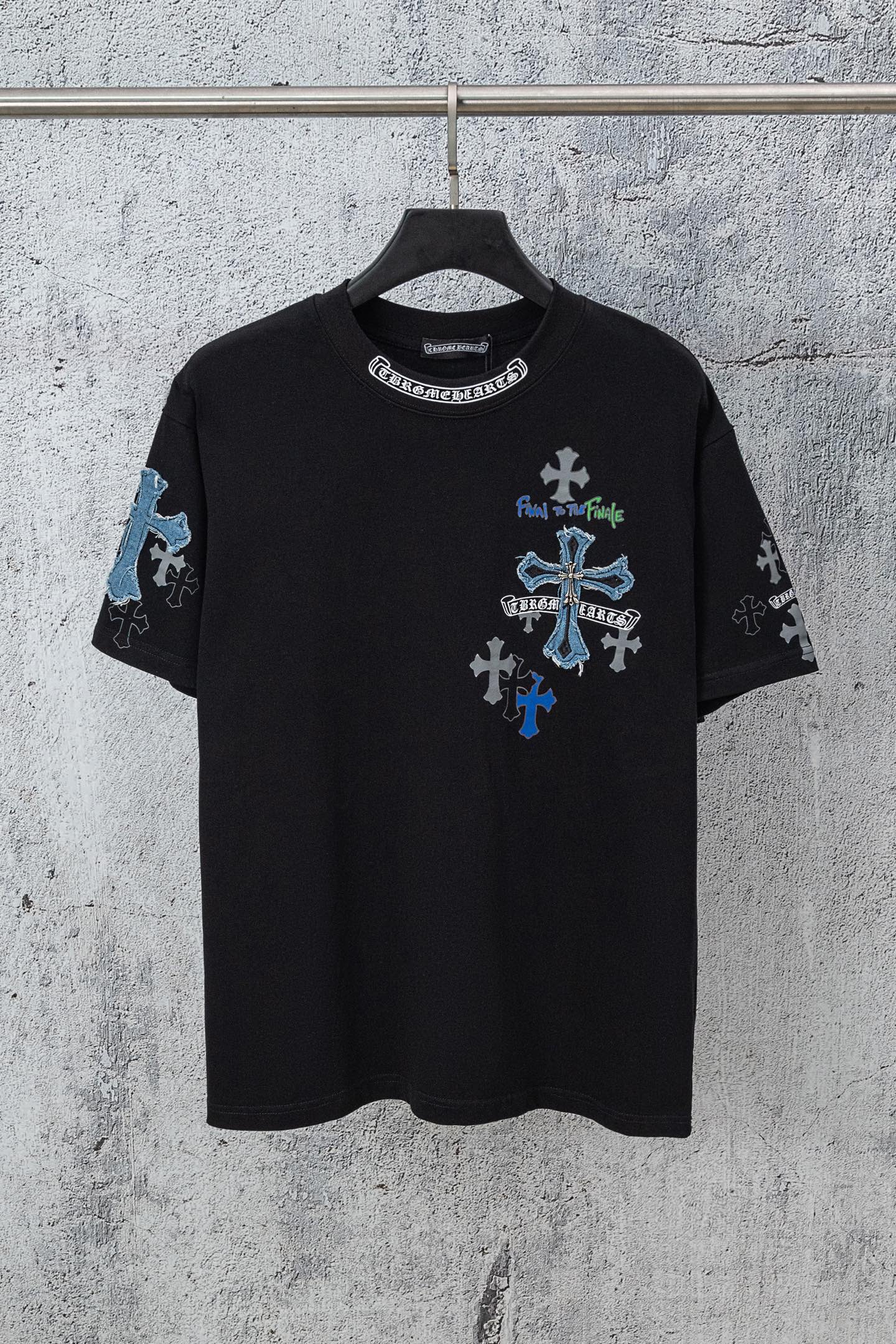 Black crew-neck T-shirt with blue cross graphic and small emblem on sleeves