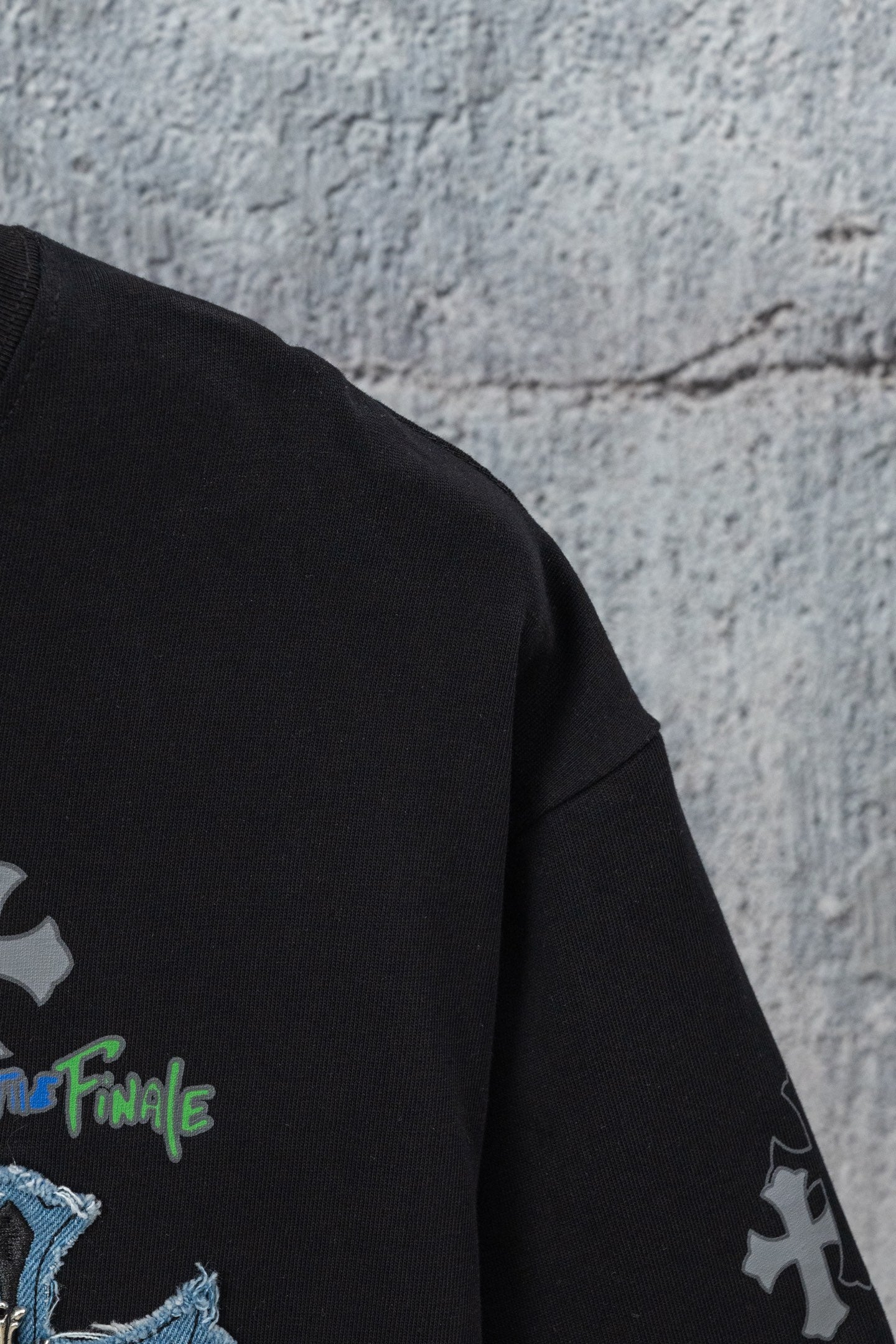 Black short-sleeve T-shirt side seam with small cross and blue lettering