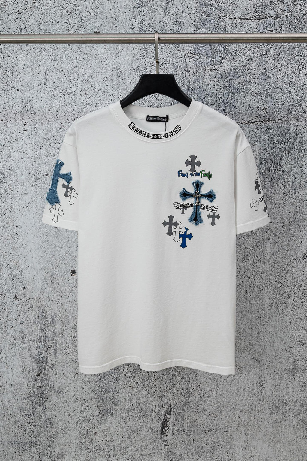 White crew-neck T-shirt with dark and blue cross graphics on chest and sleeves