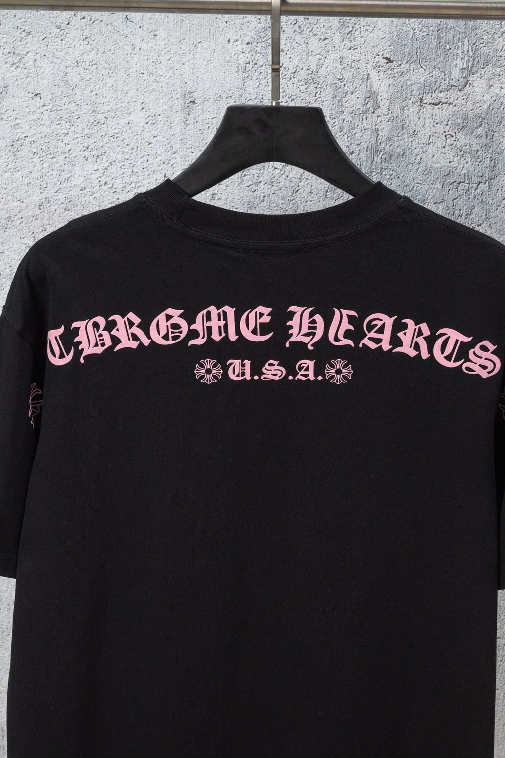 Black short-sleeve T-shirt with centered back graphic lettering and small print