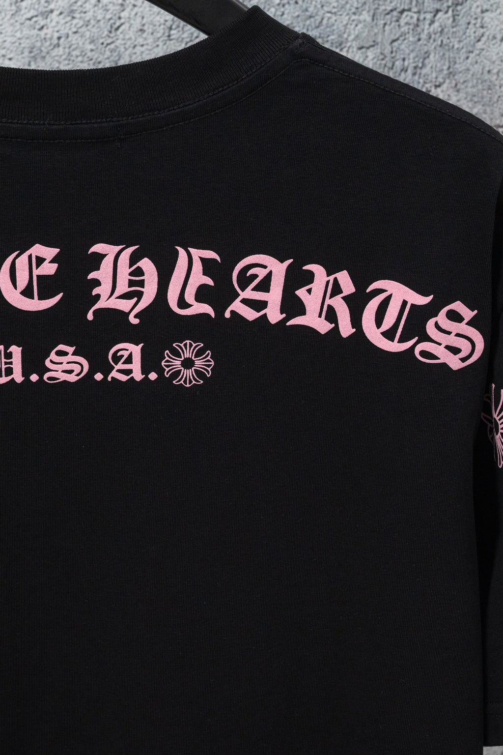 Black short-sleeve T-shirt with large pink front graphic lettering