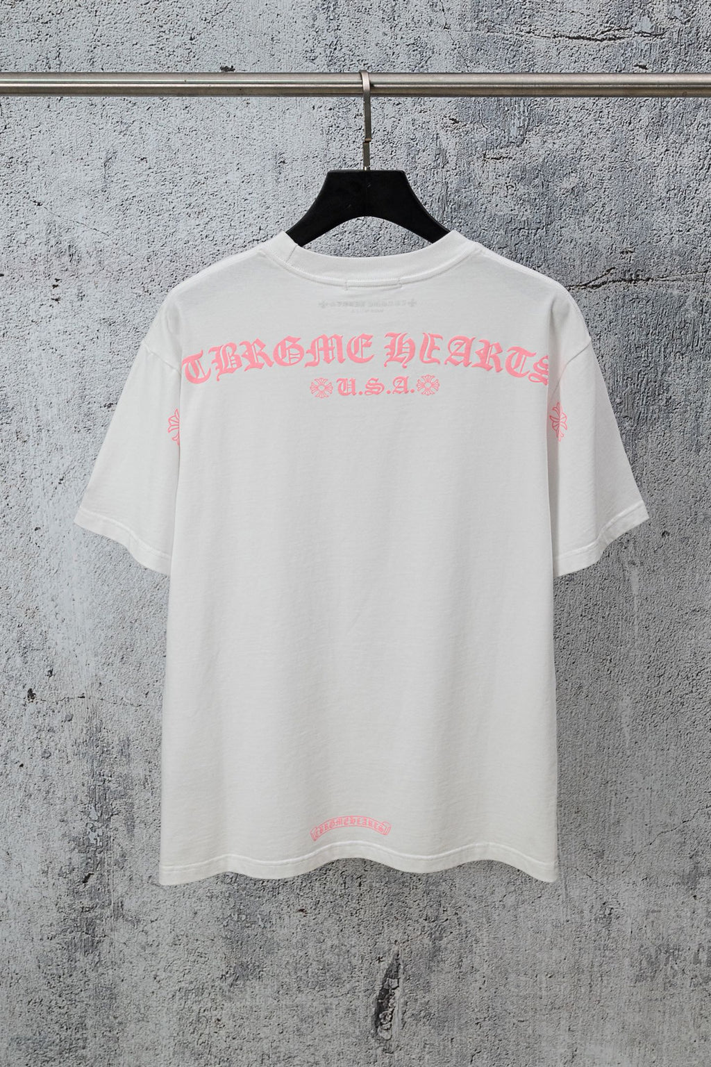 White short-sleeve T-shirt with pink graphic lettering across the chest