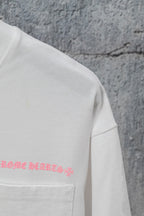 White short-sleeve T-shirt with pink graphic text near the chest pocket