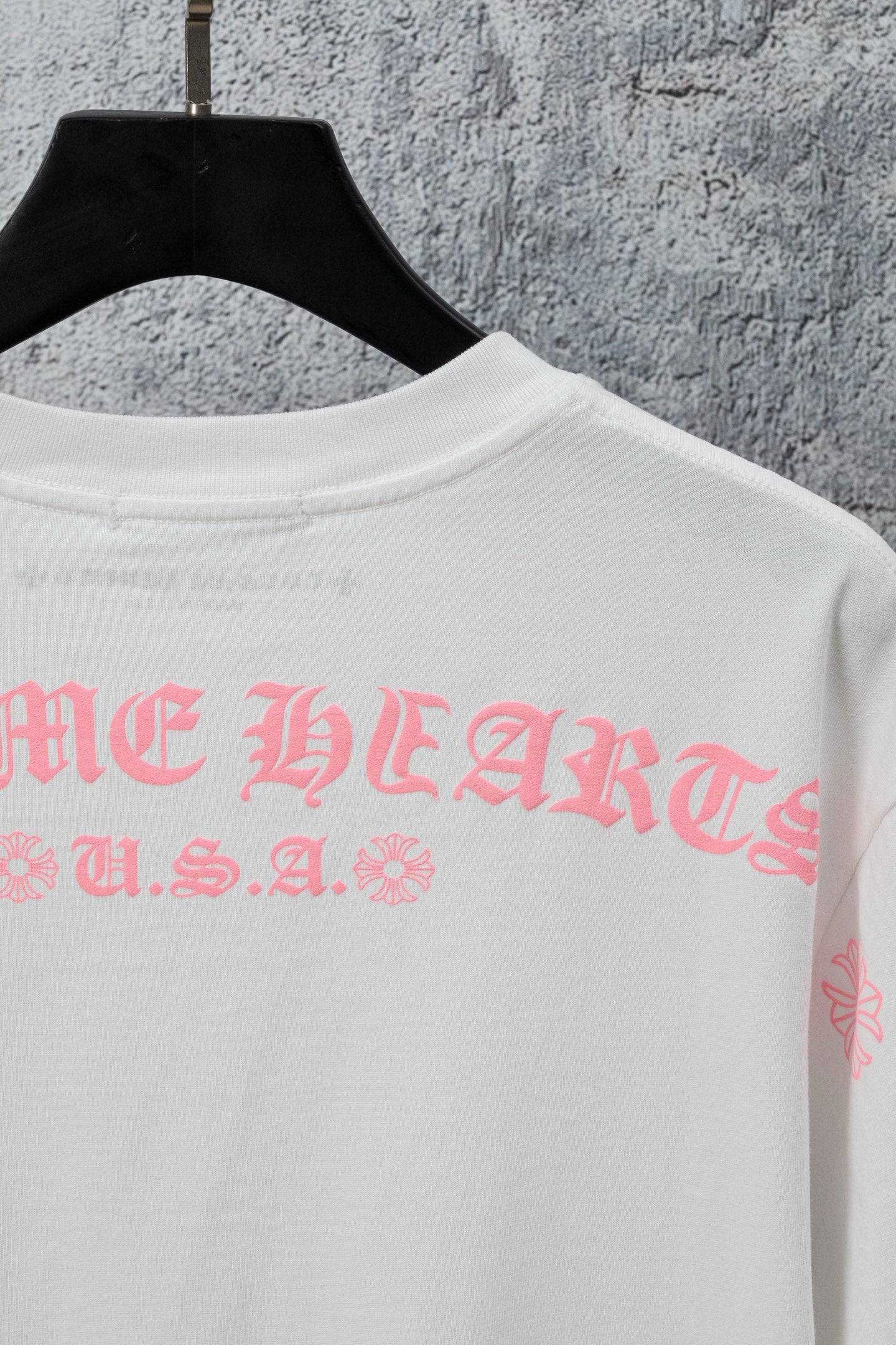 White short-sleeve T-shirt with pink graphic text across the chest