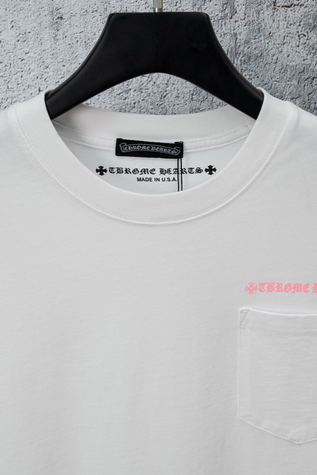White short-sleeve T-shirt neckline with pink chest lettering and pocket