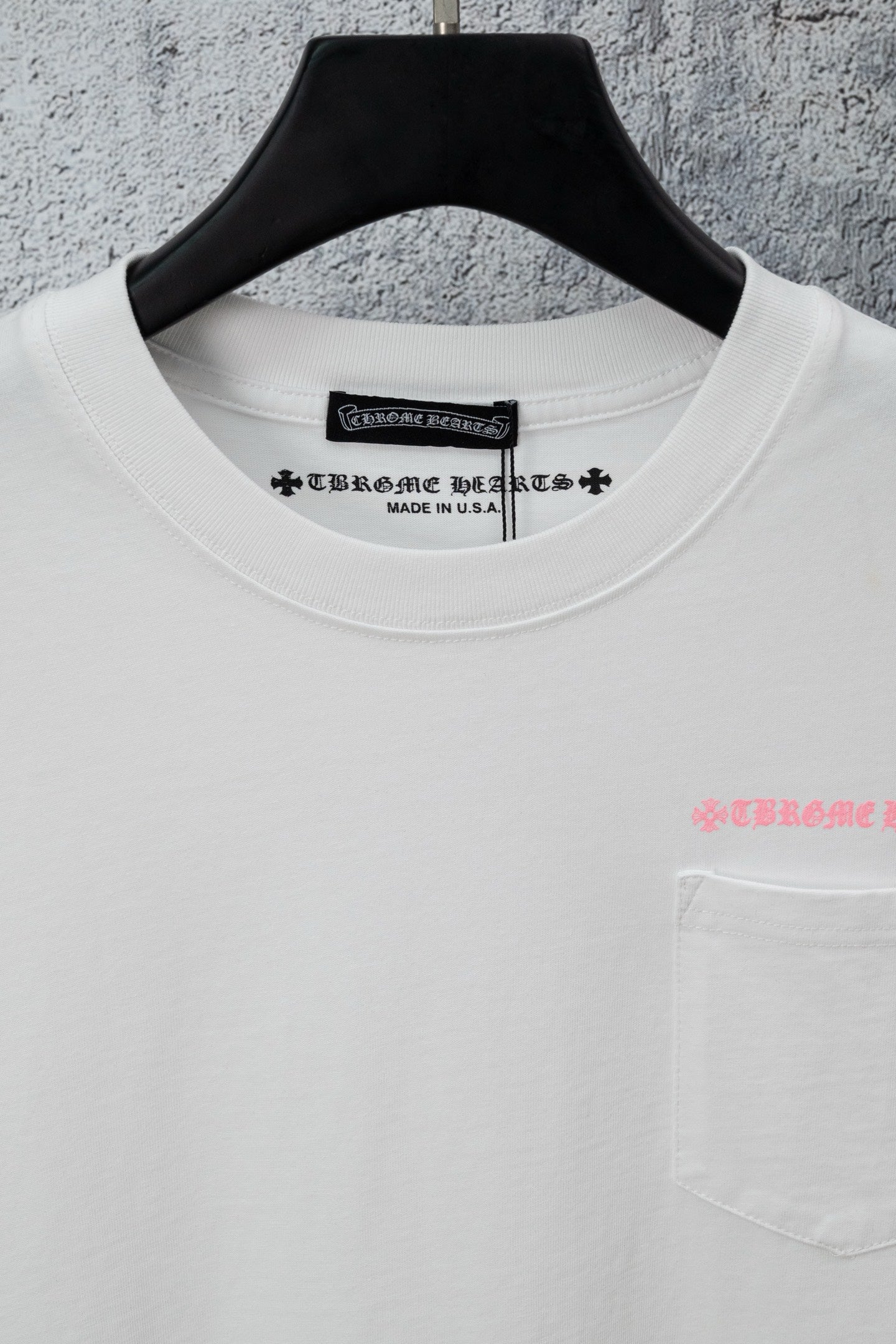 White short-sleeve T-shirt neckline with pink chest lettering and pocket