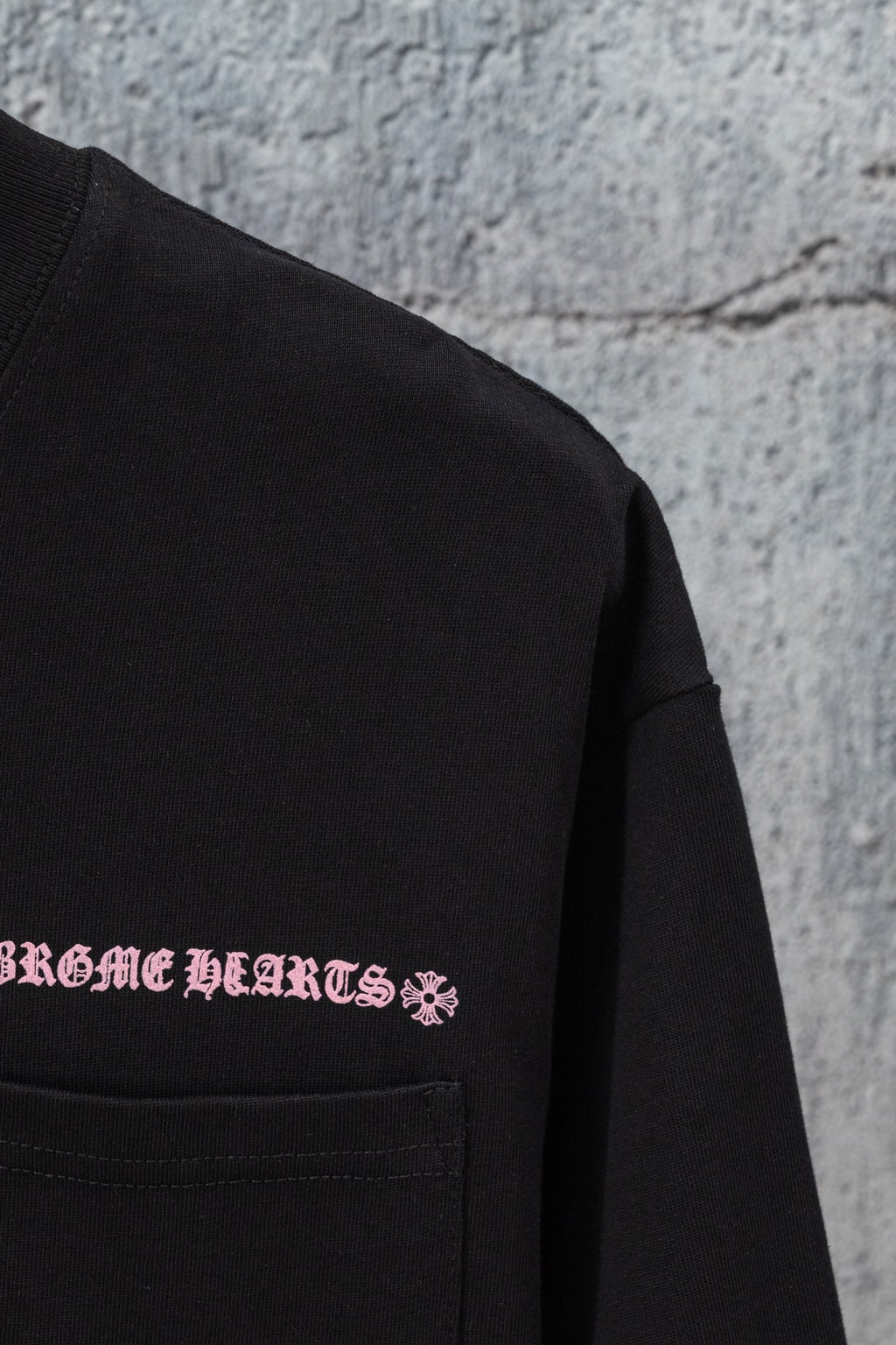 Black short-sleeve T-shirt with pink chest graphic and stitched pocket