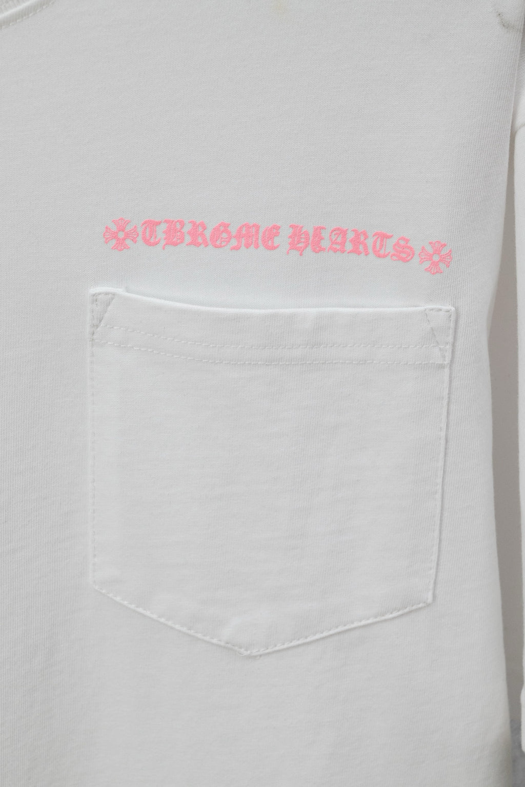 White short-sleeve T-shirt with pink graphic text over a chest pocket