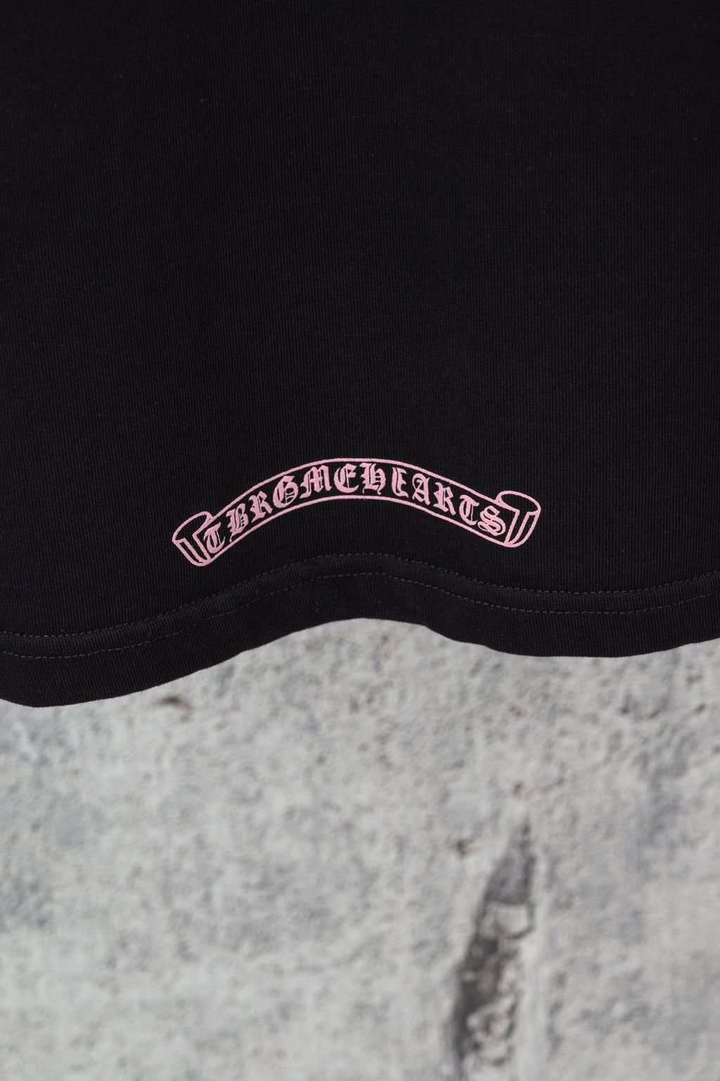 Black short-sleeve T-shirt logo patch near hem in pink