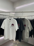 Short-sleeve T-shirts in white, black, and gray with maroon floral chest prints