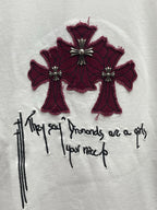 White T-shirt chest graphic of maroon cross-like flowers with black handwritten script