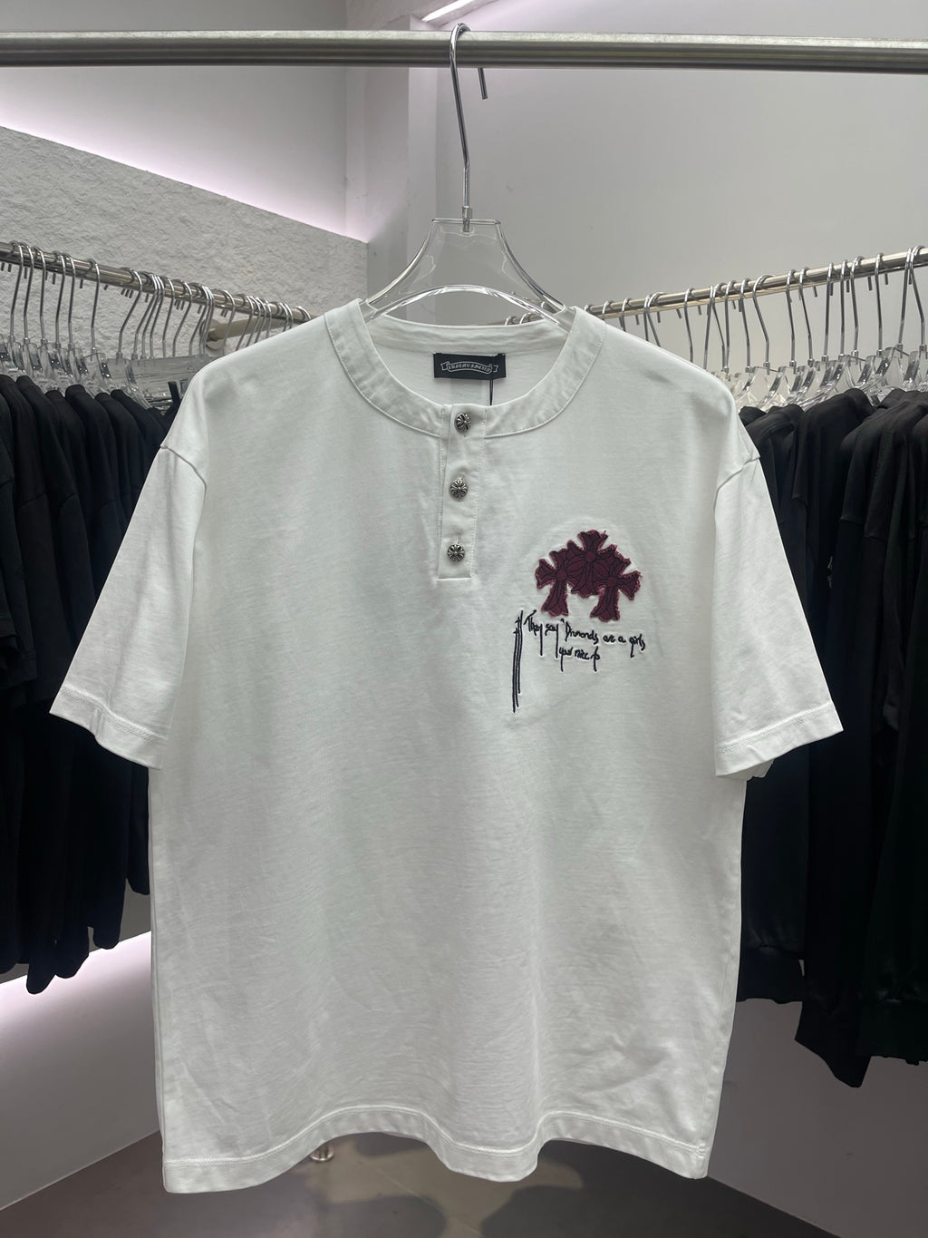 White crewneck short-sleeve T-shirt with maroon floral graphic and three-button placket
