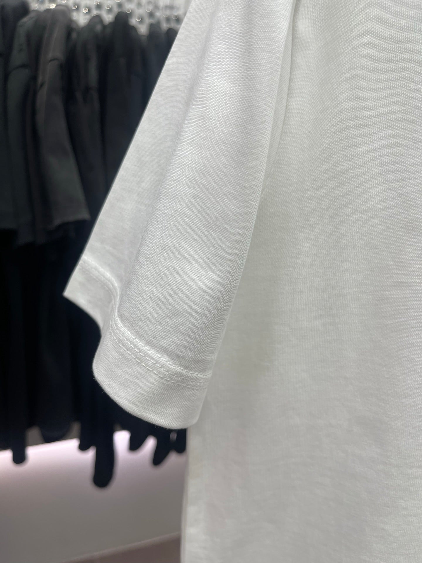 White short-sleeve T-shirt sleeve and hem detail with plain stitched cuff