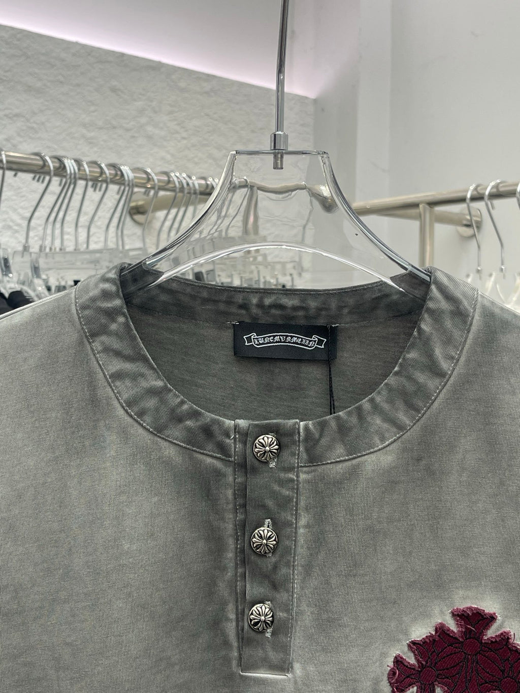 Light gray henley T-shirt with button placket and burgundy cross emblem