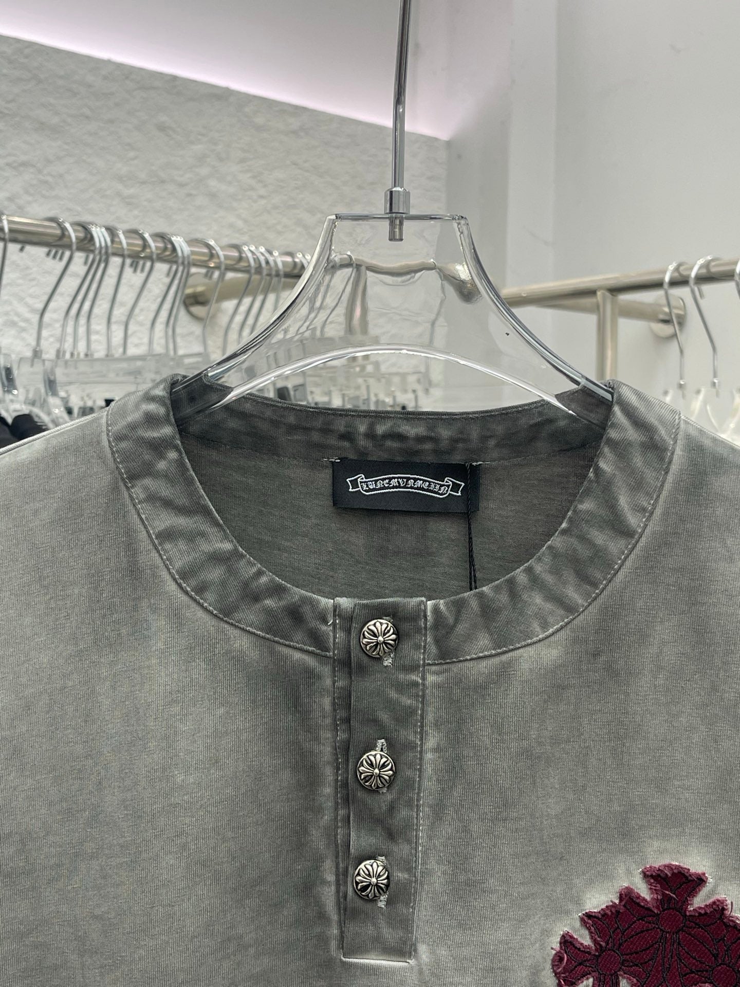 Light gray henley T-shirt with button placket and burgundy cross emblem