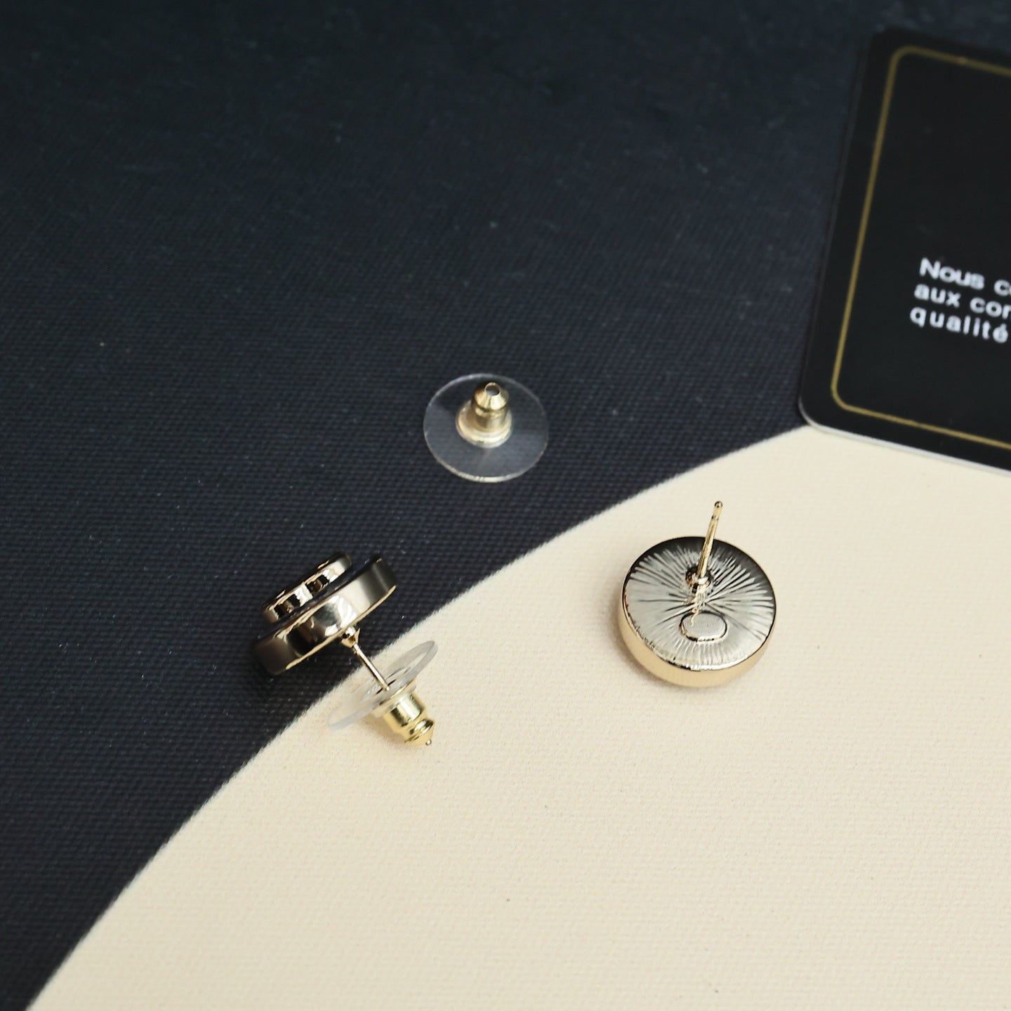 Chanel stud earrings showing gold-tone posts and round blue enamel face