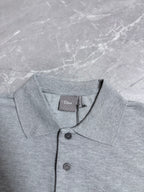 Dior polo shirt neckline close-up with dark buttons, light gray fabric
