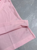 Pink polo shirt cuff with stitched edge and side seam