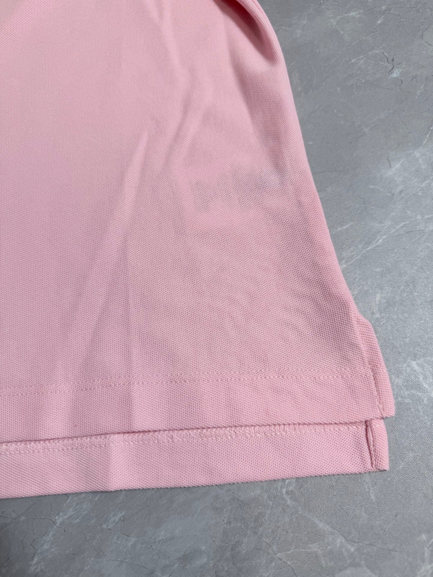 Pink polo shirt hem with stitched finish