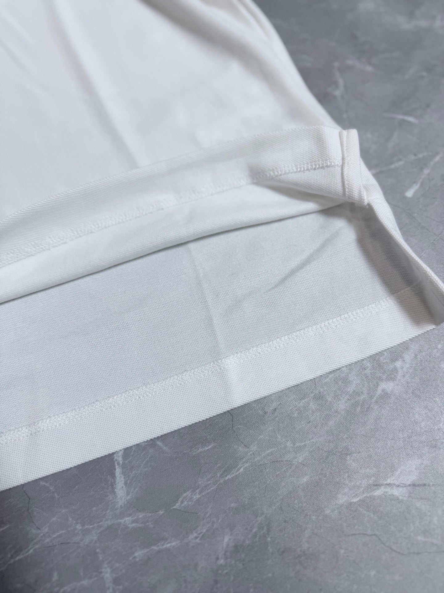 Dior white polo shirt sleeve and side panel stitching detail