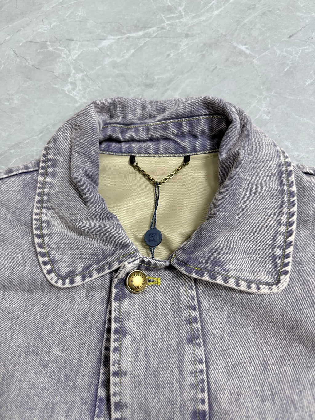Louis Vuitton denim jacket collar with yellow accents and logo hang tag