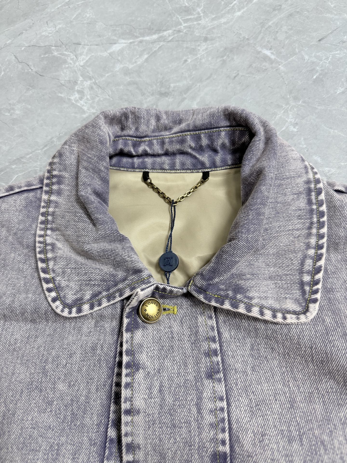 Louis Vuitton denim jacket collar with yellow accents and logo hang tag