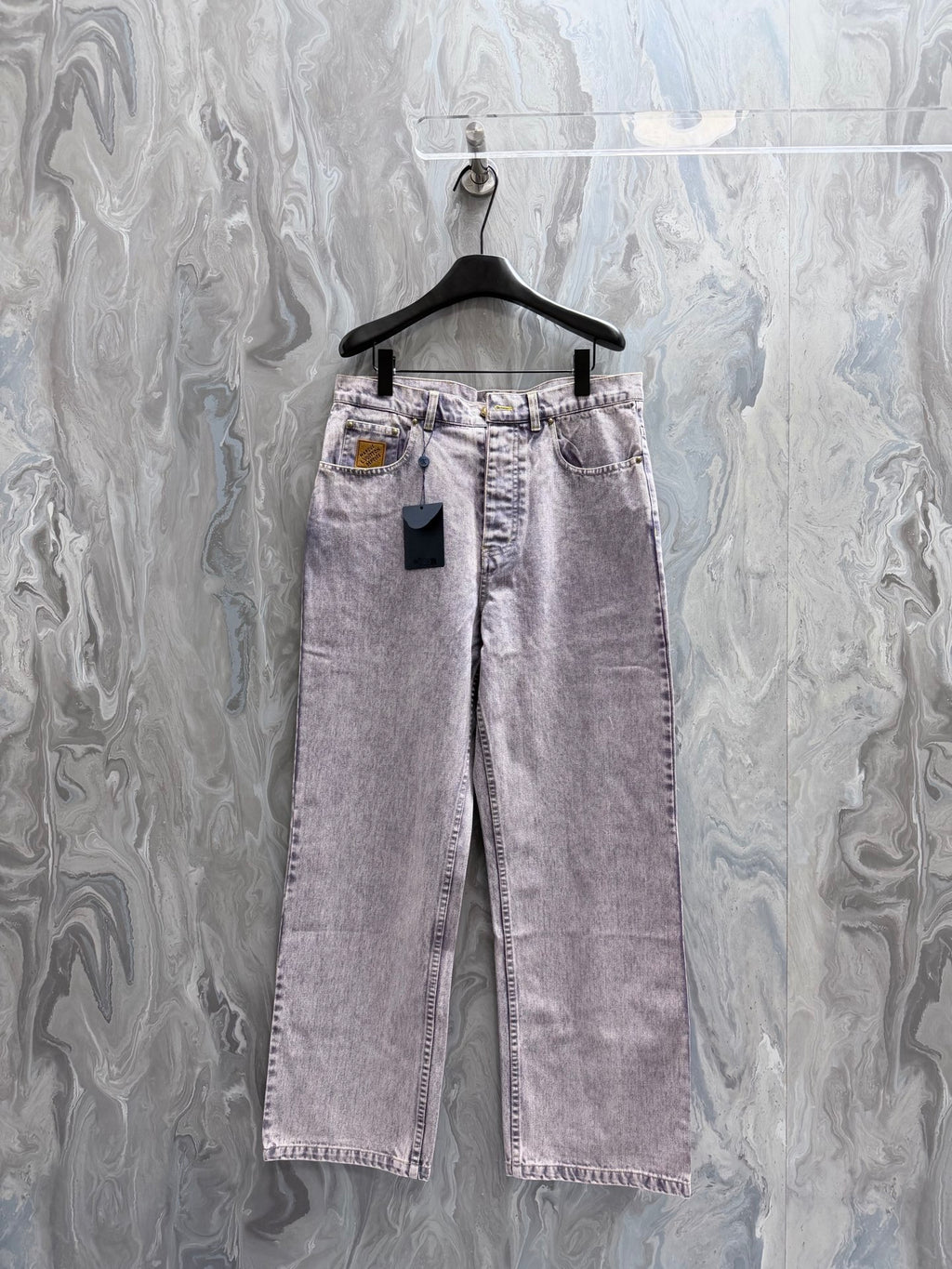 Light-wash Louis Vuitton denim pants with belt loops, front pockets, and button closure