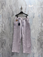 Denim pants in dark purple with front buttons and frayed hem, hanging on a hanger