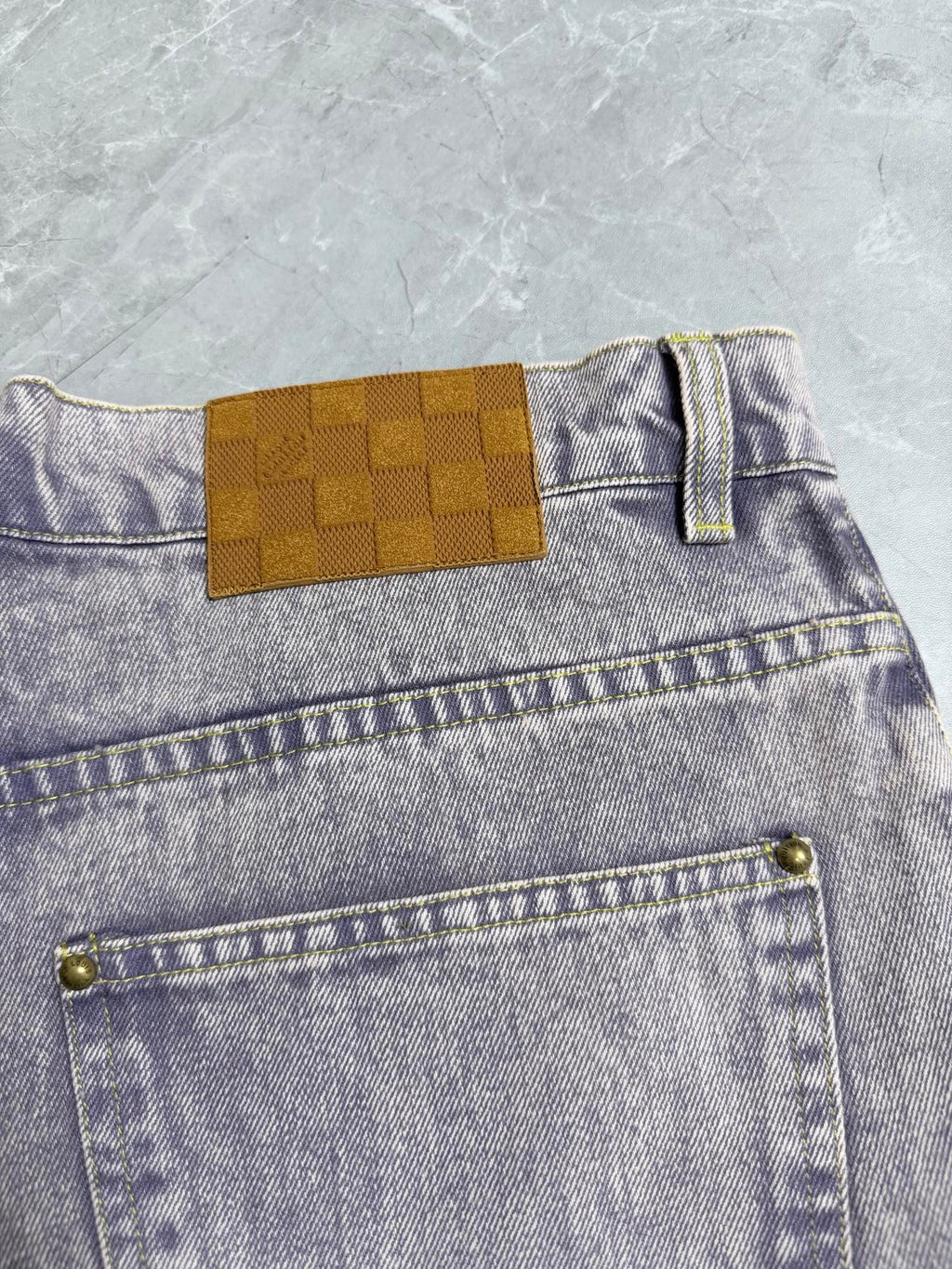 Light-wash Louis Vuitton denim pants with check-style patch and front coin pocket