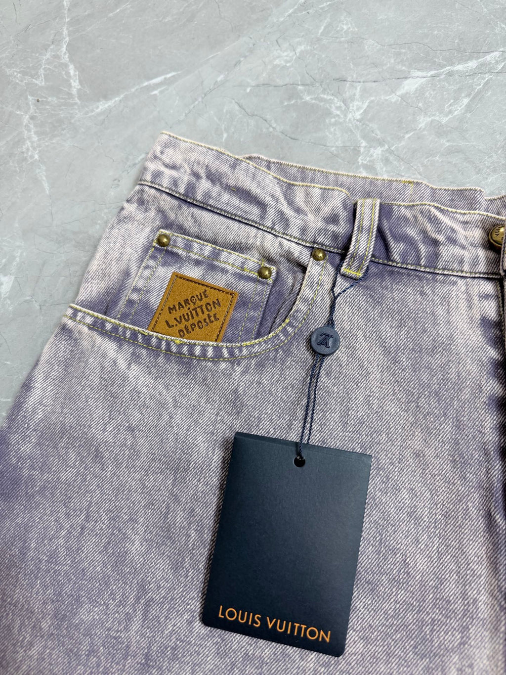 Light-wash Louis Vuitton denim pants with coin pocket and attached Louis Vuitton hang tag